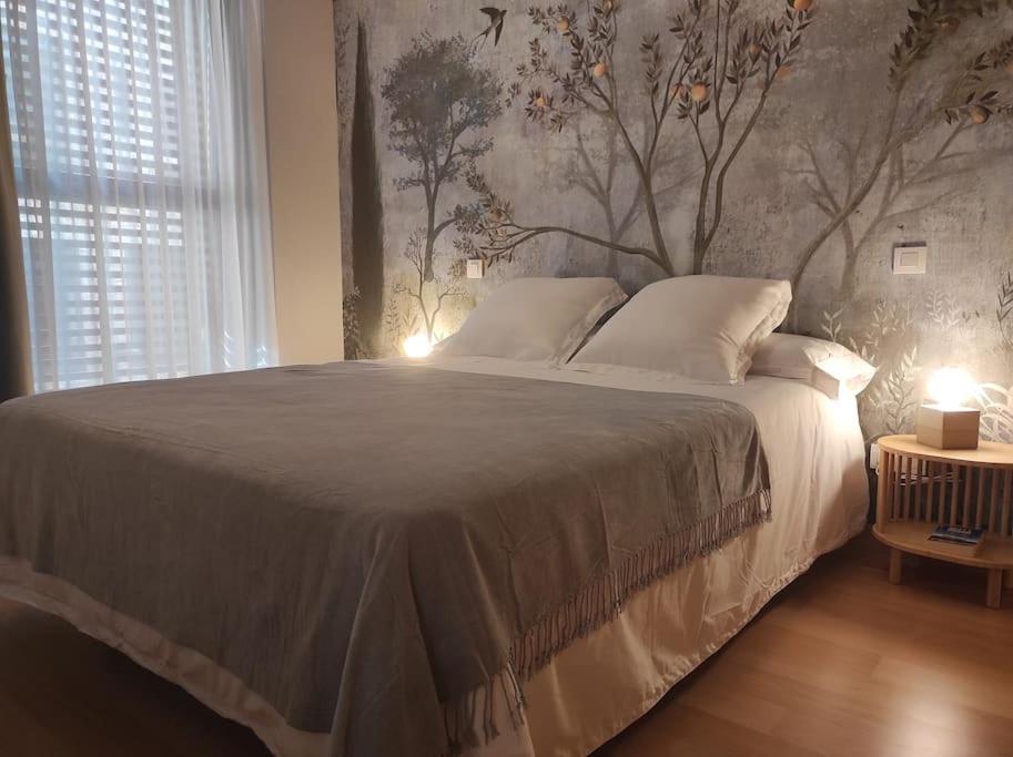 布尔戈斯Cordón 4的卧室配有一张大床和树壁画