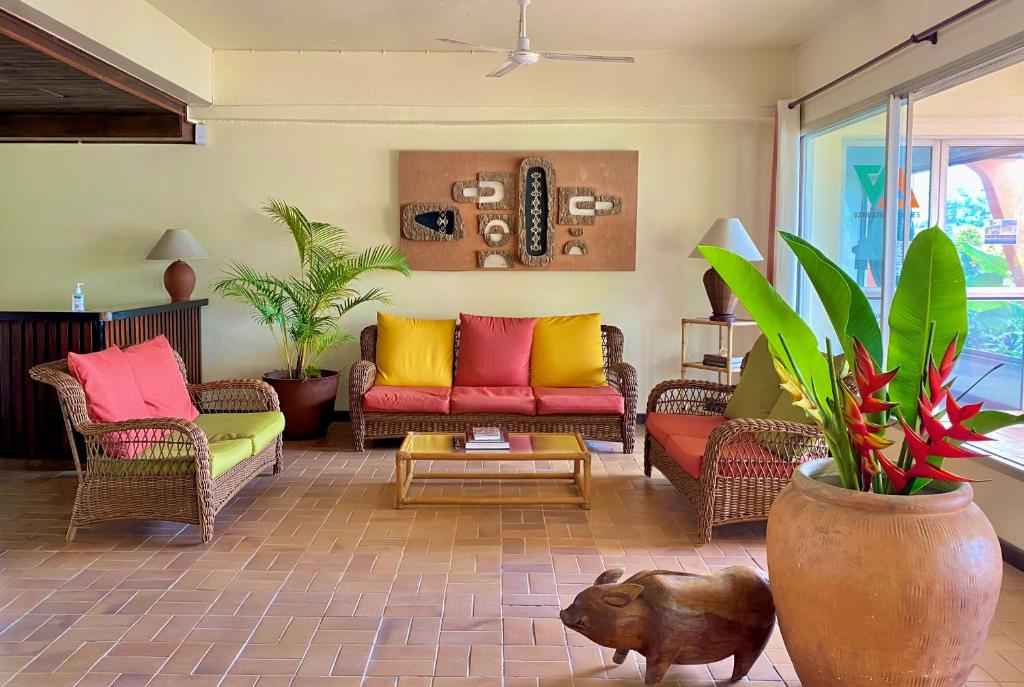 卢甘维尔Hotel Santo Vanuatu的客厅配有色彩缤纷的沙发和植物
