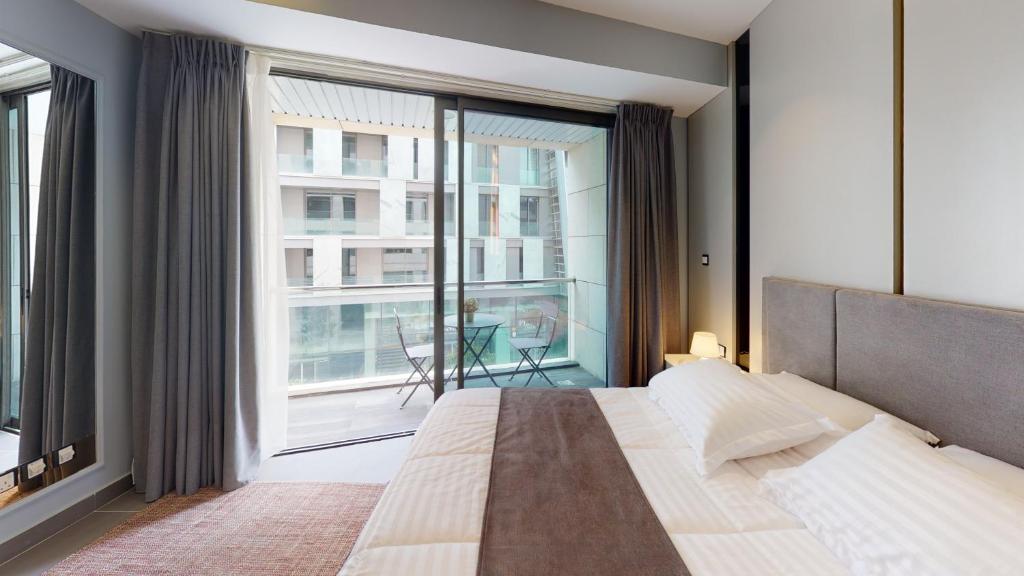 安曼Al Fares Luxury furnished Apartment-Damac Tower的一间卧室设有一张大床和一个大窗户