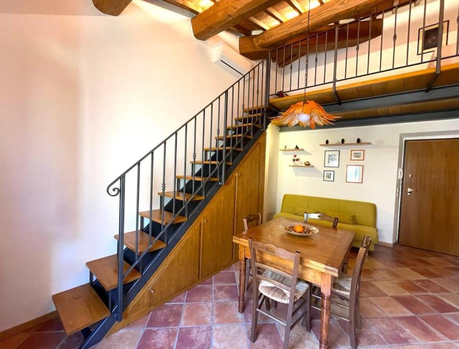 圣焦万尼瓦尔达尔诺A duecento passi- comfort nel cuore della Toscana的一间带桌子和楼梯的用餐室
