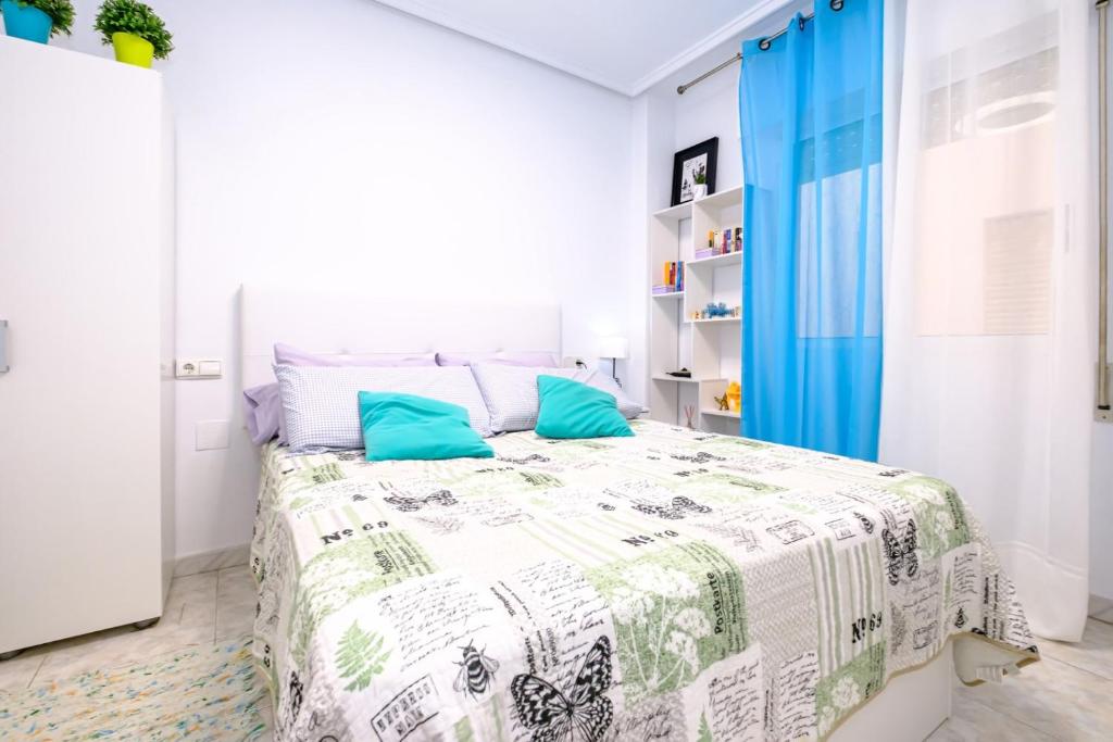 托雷维耶哈ALEGRIA ID18的白色卧室配有一张带蓝色窗帘的床