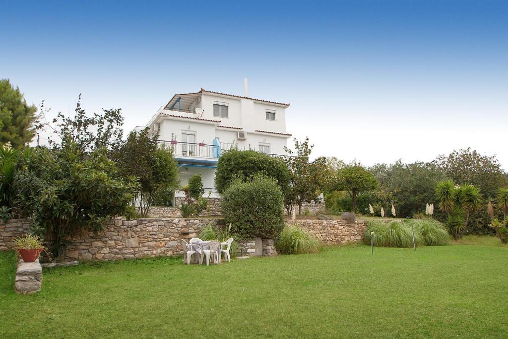 考考纳里斯Villa ALEXIS的一座带两把椅子的大白色房子