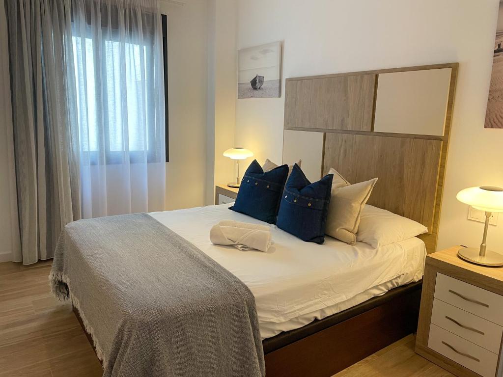 福恩吉罗拉La Rosa Apartment Los Boliches Fuengirola Malaga Spain的一间卧室配有一张带蓝色枕头的大床