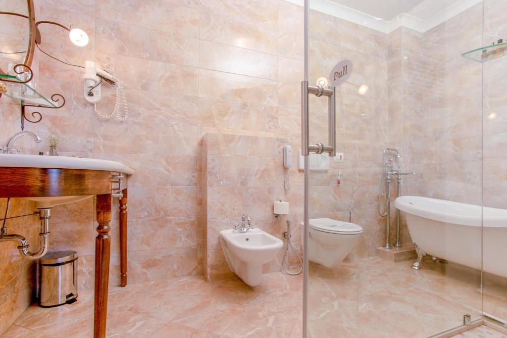普里什蒂纳花园酒店的带浴缸、卫生间和盥洗盆的浴室