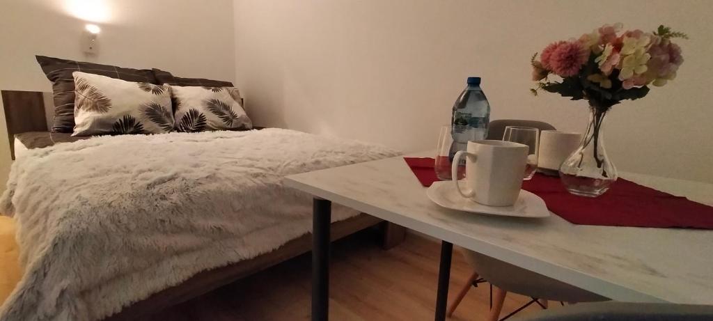 索斯诺维茨Apartament Sosnowiec - Kazimierz Górniczy的一间卧室配有一张床和一张鲜花桌