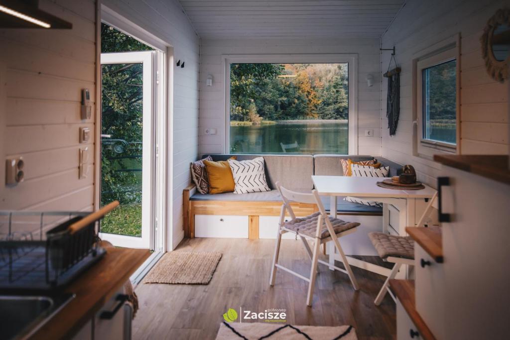 普日维兹Półwysep Zacisze - Tiny House Village的一个小房子,设有门廊,配有沙发和桌子