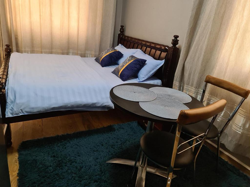 坎帕拉Unia fancy flats - studio apartment two的卧室配有一张床和一张桌子及椅子