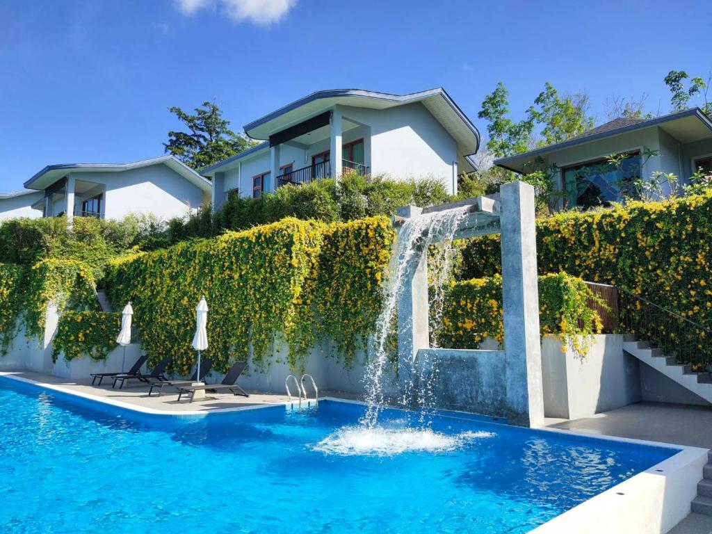 蔻立Khaolak Blue Sky Villa的一座房子前面带瀑布的游泳池