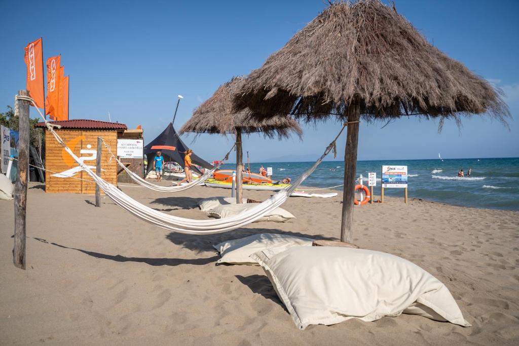 卡斯蒂里昂纳·德拉佩马雷玛圣苏西露营酒店的海滩上设有两张吊床和一把草伞