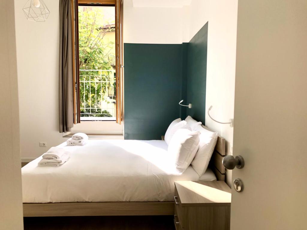 米兰RELSTAY - Amendola的一间卧室配有一张带绿色床头板的床和窗户