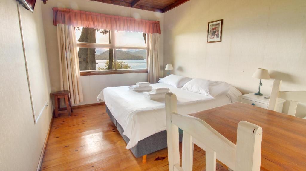拉安戈斯图拉镇贝尔韦代雷宾馆的一间卧室配有一张床、一张桌子和一个窗户。