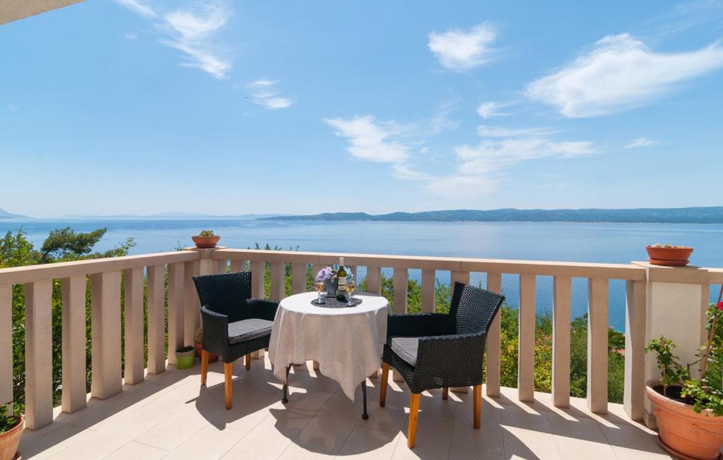 皮萨克Villa Anči的阳台配有桌椅,享有水景