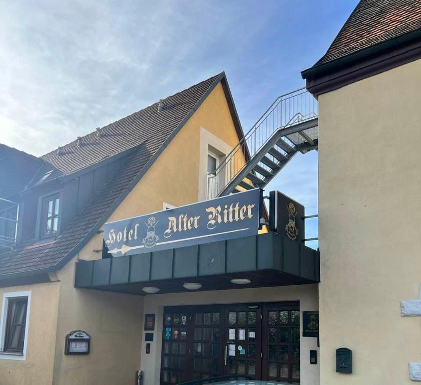 罗滕堡Hotel-Gasthof "Alter Ritter"的一块有黄油后甜食的标志的建筑