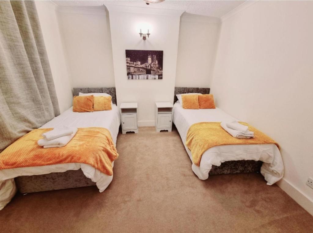 温莎Inviting 2-Bed Cottage in Windsor的白色墙壁客房的两张床