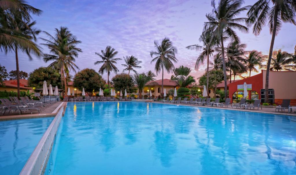 班珠尔Ocean Bay Hotel & Resort的度假村内一座种有棕榈树的大型游泳池
