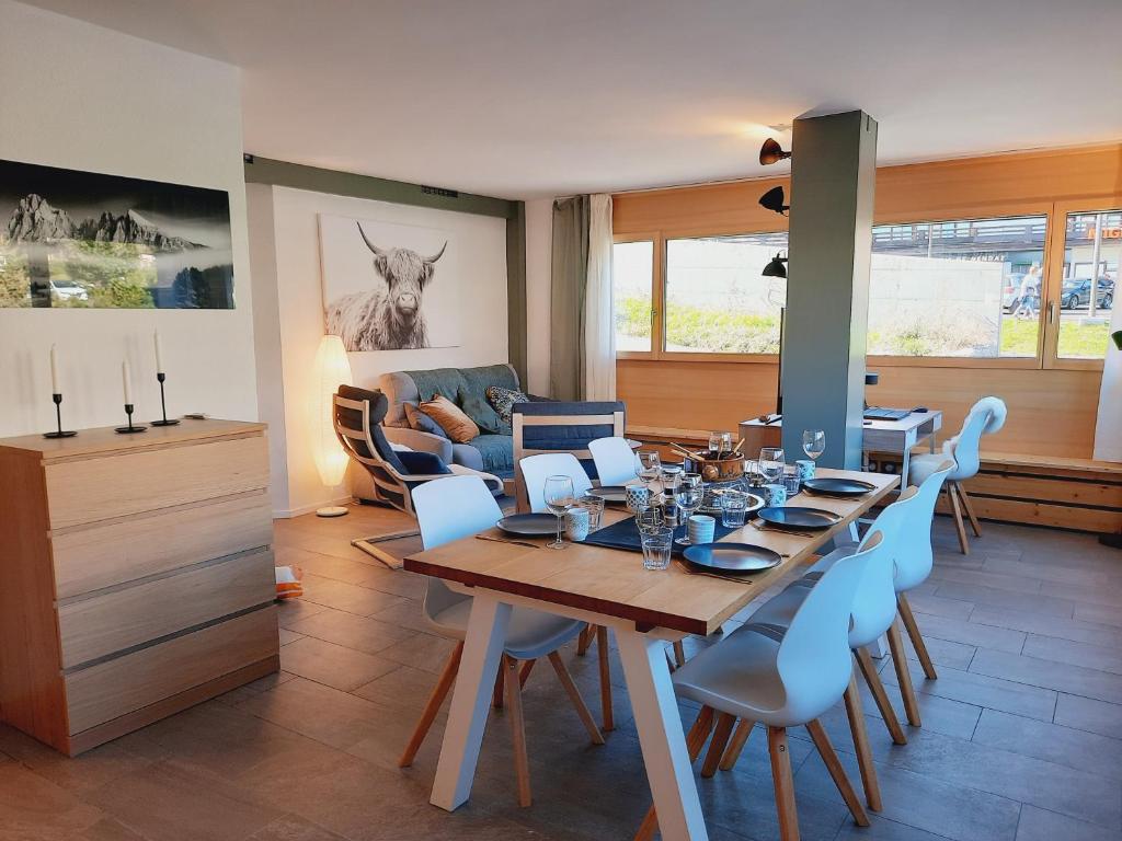 南达Le Fleuron - Cosy and well centered - 6 ppl的一间带桌子和蓝色椅子的用餐室