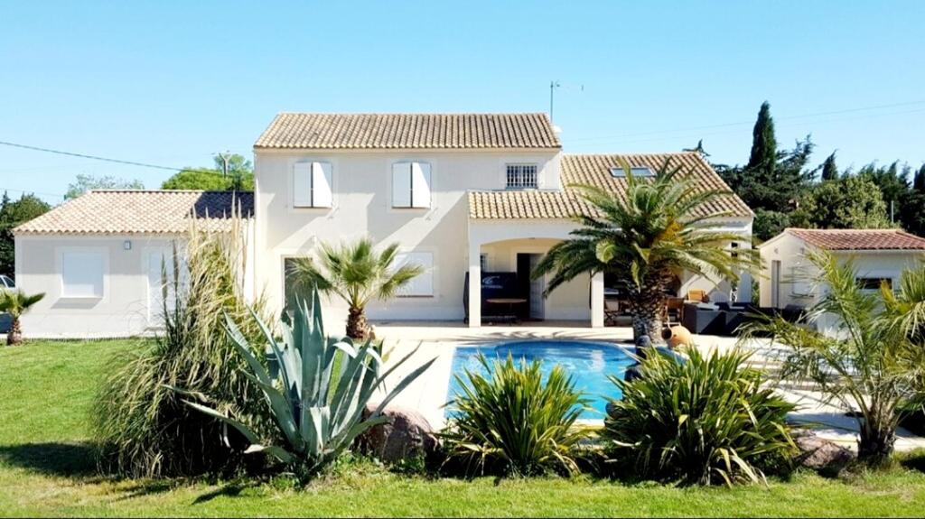奥朗日Chambre carpediem的一座带游泳池和棕榈树的房子