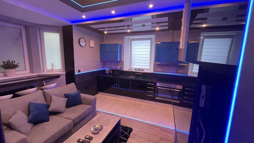阿斯隆#1 TGHA Luxury Studio Apartment in Athlone的带沙发的客厅和带蓝光的厨房