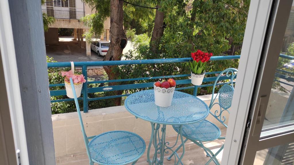 雷霍沃特Lovely studio with balcony的阳台配有一张桌子和两把带鲜花的椅子