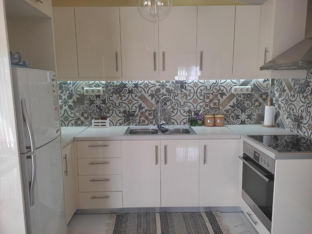 雅典Feel Like Home的厨房配有白色橱柜和水槽