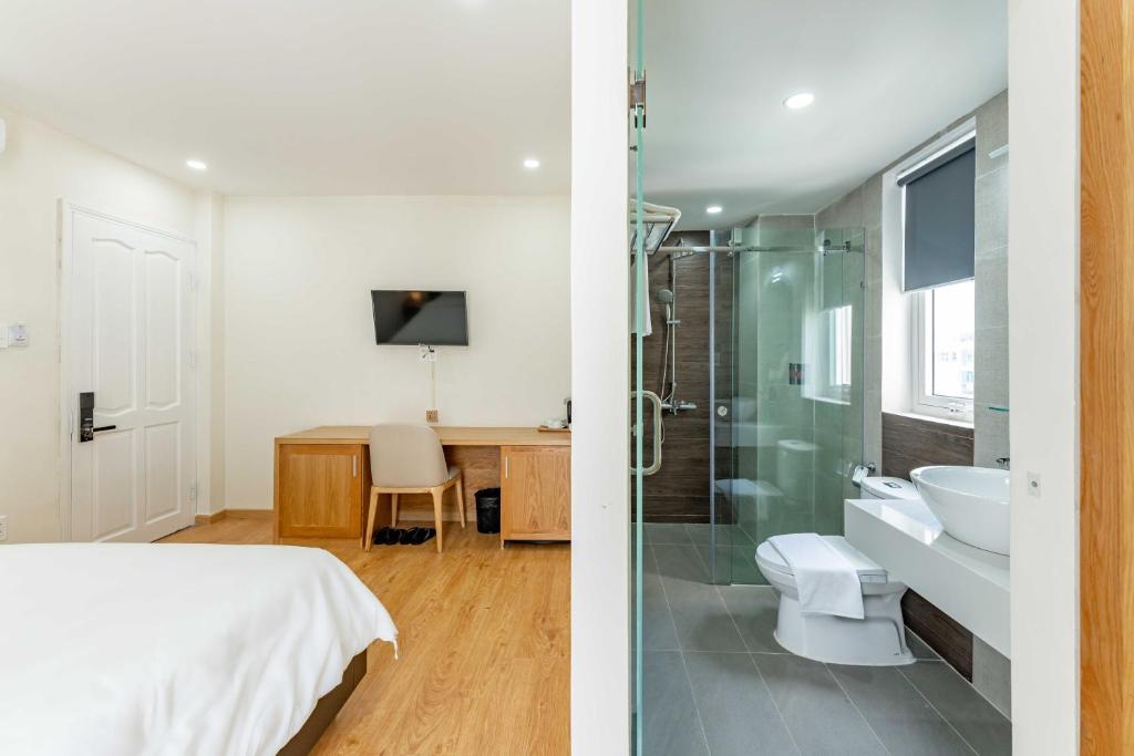 胡志明市Edoya hotel Dong Khoi的一间卧室配有一张床,浴室设有淋浴。