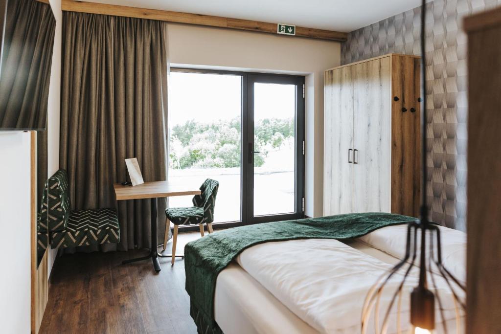Kirchbach in SteiermarkKickmaier's的配有一张床、一张书桌和一扇窗户的酒店客房