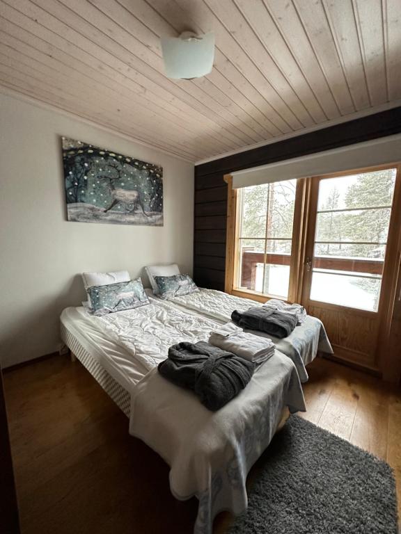 列维Villa Utsuntuisku的一间卧室设有两张床和大窗户