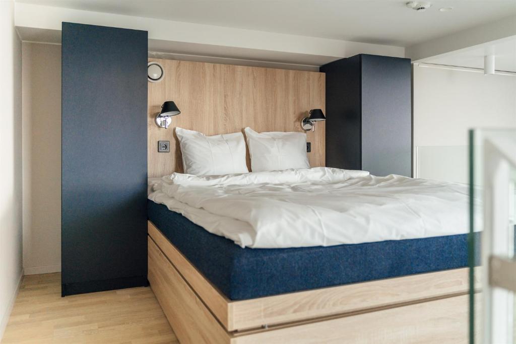 赫尔辛基UNITY Helsinki的一间卧室配有一张大床和蓝色床头板
