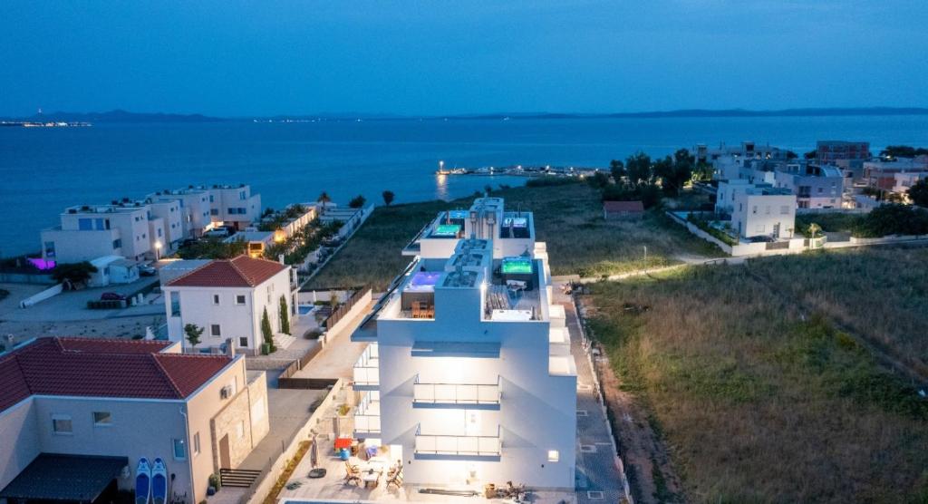 普利拉卡Villa Miri III的一组以海洋为背景的白色建筑