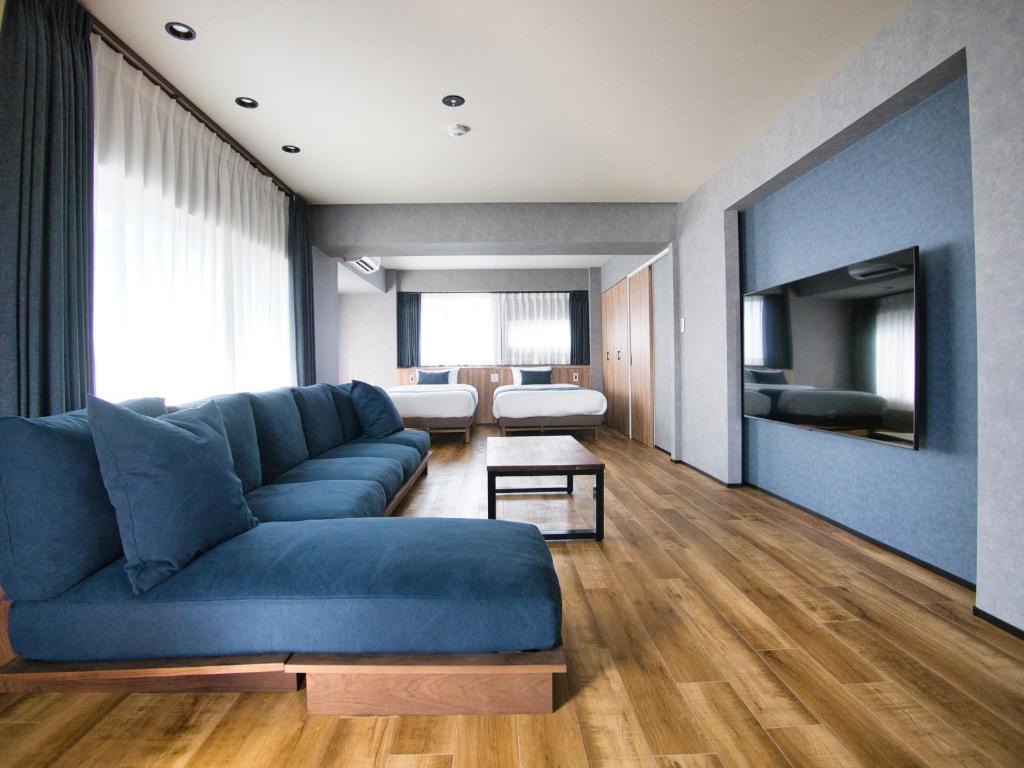 东京ulu Tokyo的客厅配有蓝色的沙发和电视