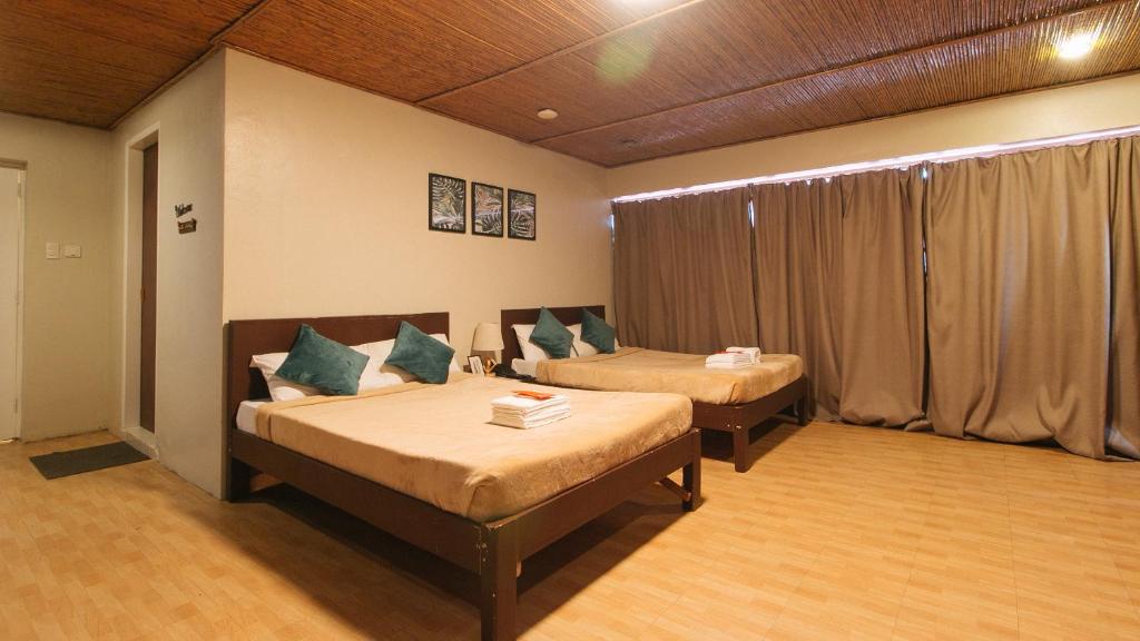 马尼拉RedDoorz @ Manila Airport Hotel的客房设有两张床和窗户。