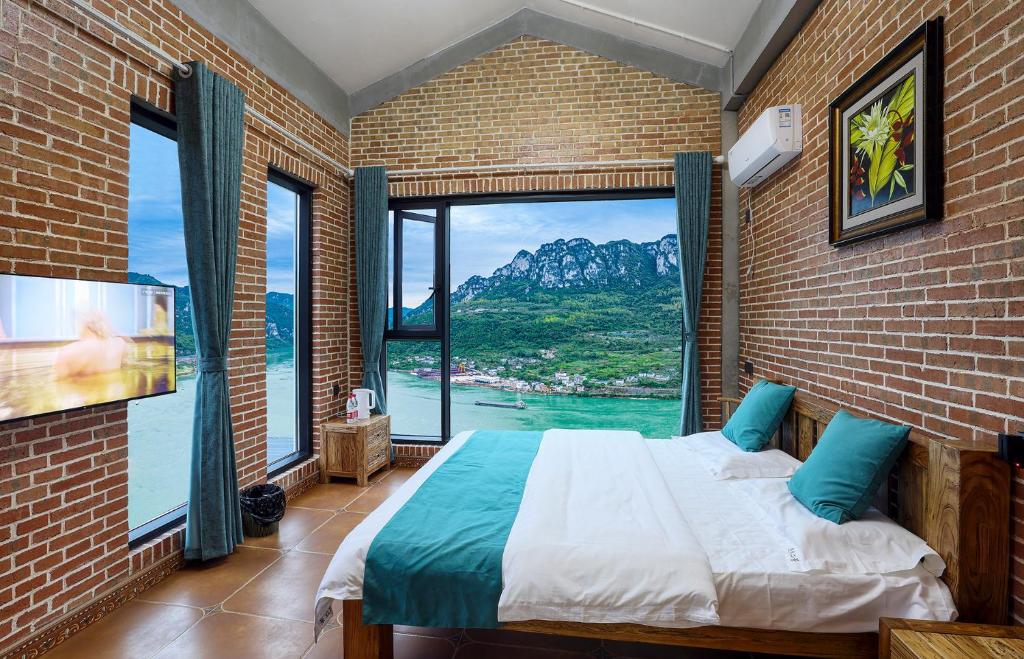 宜昌悠然江景客栈的一间卧室设有一张床和一个大窗户