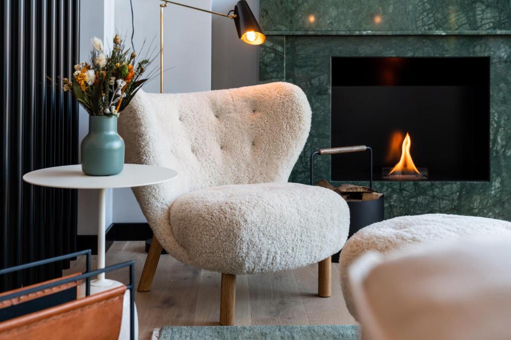 弗莱堡Black F Tower - Serviced Apartments的客厅配有椅子、桌子和壁炉