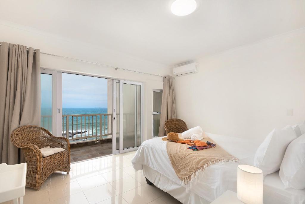 乌姆德洛蒂Escape to a Beach Haven - 505 Sorjente的一间白色卧室,配有床和阳台