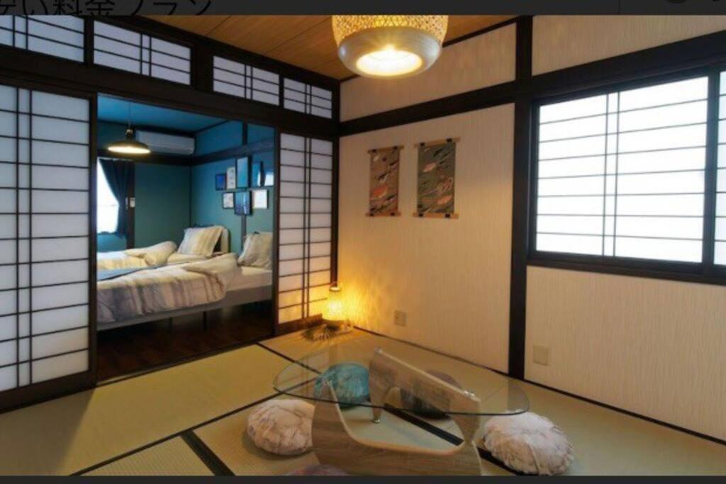 高松民宿　setouchi的带玻璃桌的房间和配有床的房间