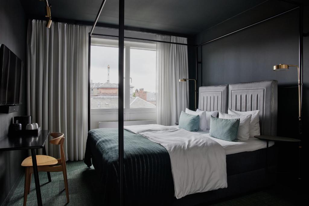 哥本哈根Hotel Danmark by Brøchner Hotels的一间卧室设有一张大床和窗户