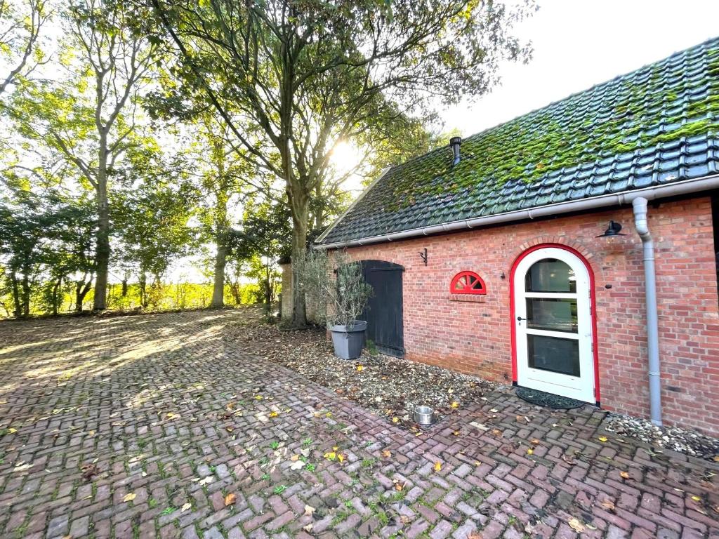 坎珀兰Boerderijstudio Kamperland的红砖建筑,有白色门