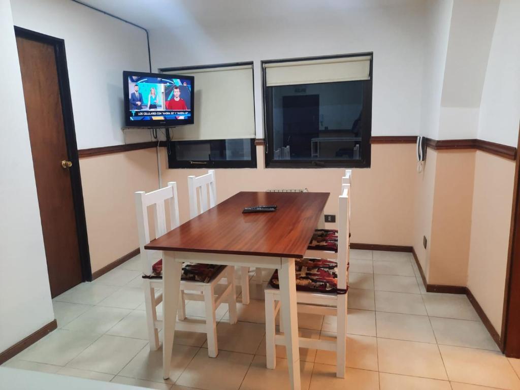乌斯怀亚Departamento Centrico Ushuaia的一间带桌椅和电视的用餐室