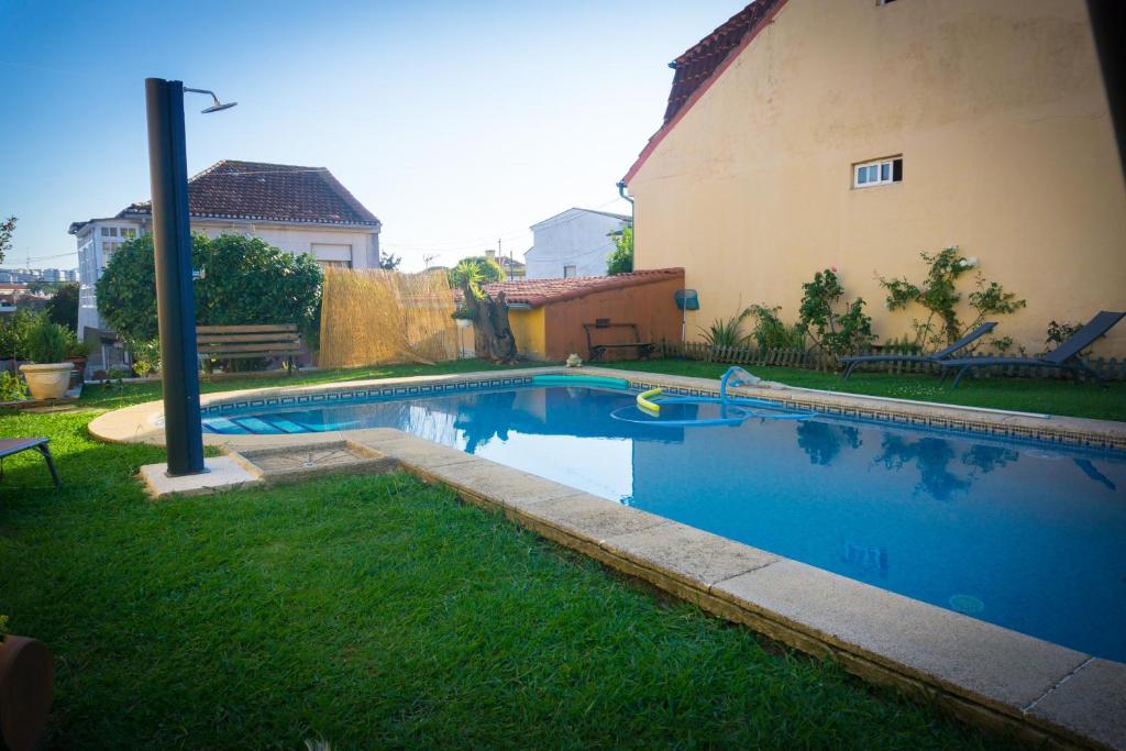 维戈Apartamento con piscina privada的一座房子旁的院子内的游泳池