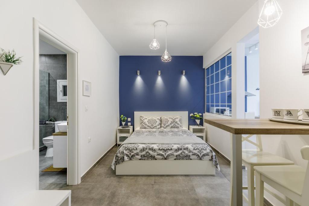 塞萨洛尼基NAVA Apartment in the center of Thessaloniki的一间卧室设有一张床和蓝色的墙壁