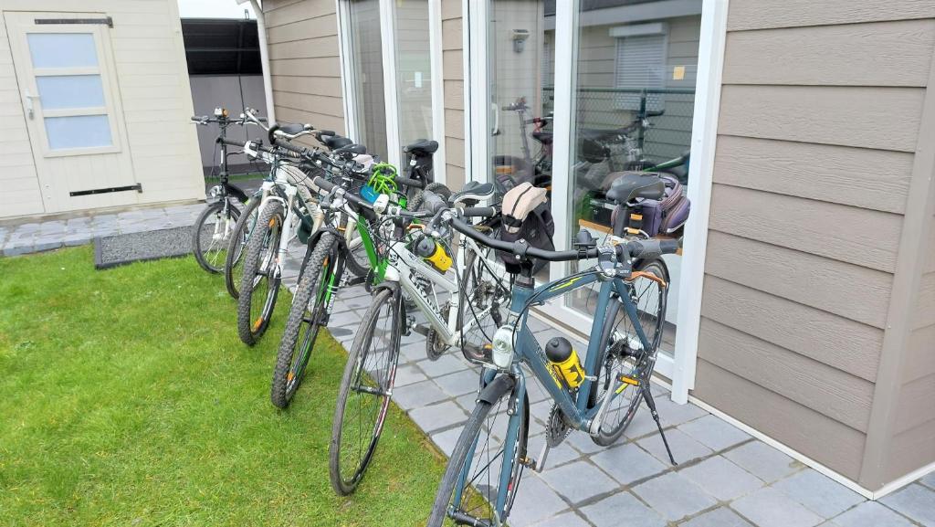 克诺克－海斯特Luxe cottage met fietsen, airco & infrarood cabine的停在房子边的一排自行车