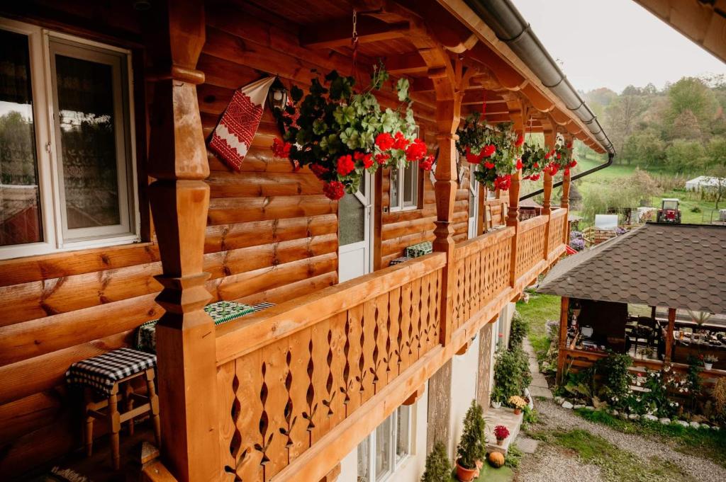 BrebCasa Pintea de Sub Coastă的阳台上的木房子,种有鲜花