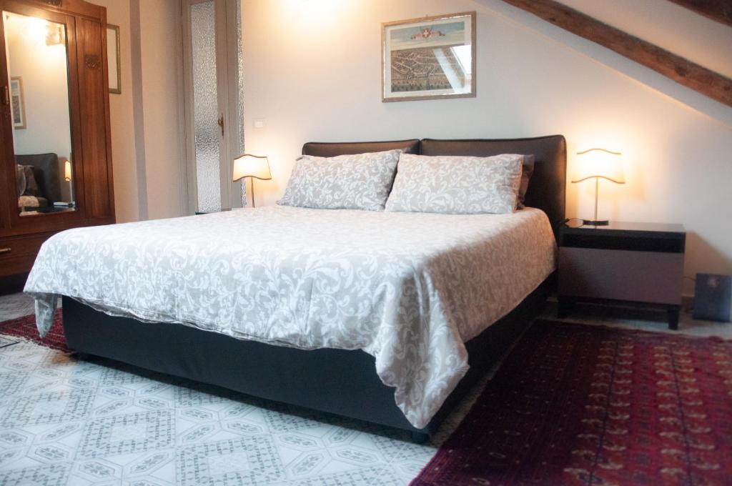 都灵Suite Sommeiller Comfort in centro的一间卧室配有一张大床和两盏灯。