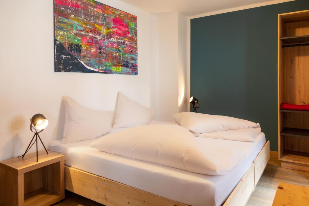 基茨比厄尔Gästehaus Johanna的卧室配有一张白色床,墙上挂有绘画作品