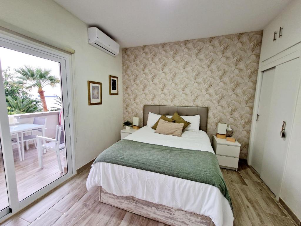 圣克鲁斯-德特内里费Pequeño paraíso frente al mar Playa Chica的一间带大床的卧室和一个阳台