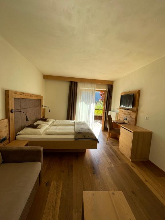 韦尔图尔诺莫亚里霍夫酒店的一间卧室配有一张床、一张沙发和一台电视