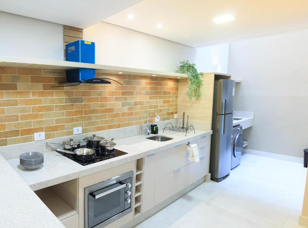 伊瓜苏Apartamento completo - Vila A的厨房配有水槽和冰箱