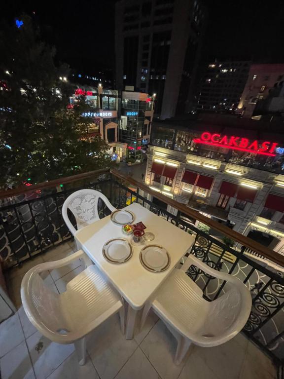 巴库Fountain Square-Balconies in Old Town的夜晚阳台上的白色桌椅