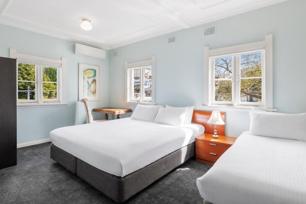 肯图巴Hotel Blue & Cottages Katoomba的带2扇窗户的客房内的2张床