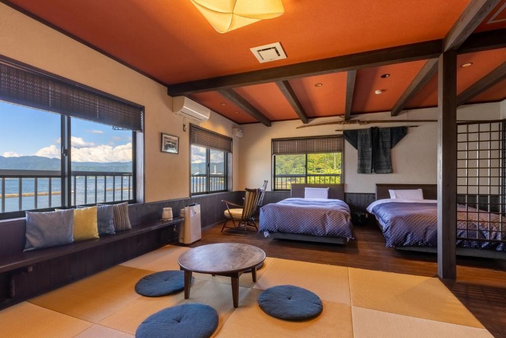 敦贺市Tsuruga Sazanami Resort Chobei的一间卧室配有两张床和一张桌子